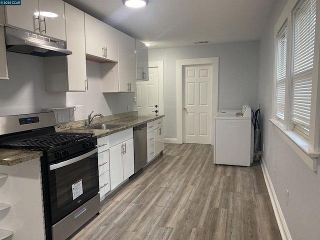 kitchen featuring white cabinetry, appliances with stainless steel finishes, washer / clothes dryer, and sink