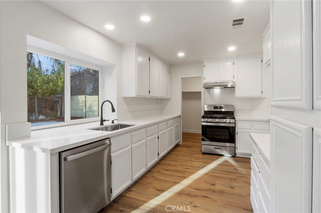 kitchen featuring white cabinetry, sink, and appliances with stainless steel finishes