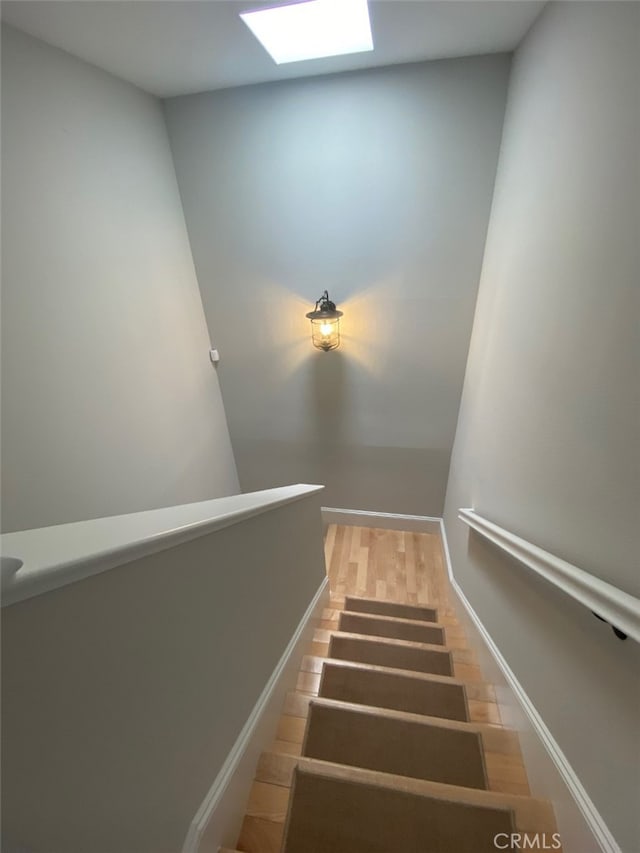 stairs with wood finished floors and baseboards