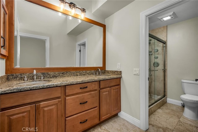 bathroom featuring a shower with door, vanity, and toilet