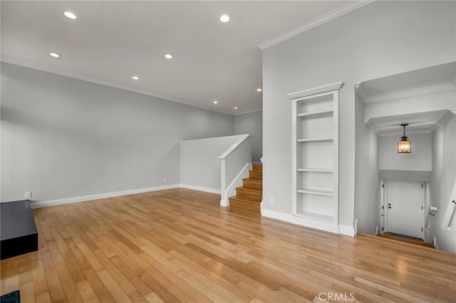unfurnished living room featuring crown molding, built in features, light wood-style flooring, and stairs