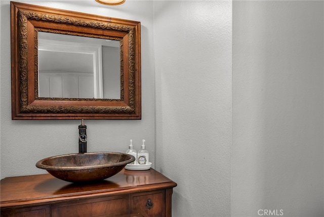 bathroom featuring vanity and a textured wall