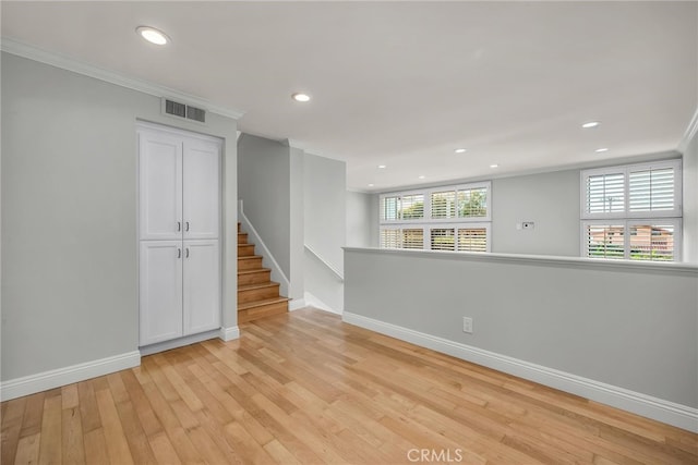 unfurnished room featuring crown molding, a healthy amount of sunlight, and light wood-type flooring