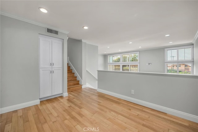 unfurnished room featuring light wood-type flooring, ornamental molding, visible vents, recessed lighting, and baseboards