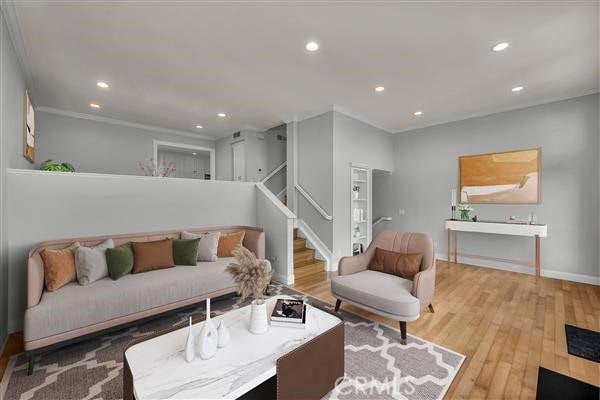 living room with hardwood / wood-style flooring and ornamental molding