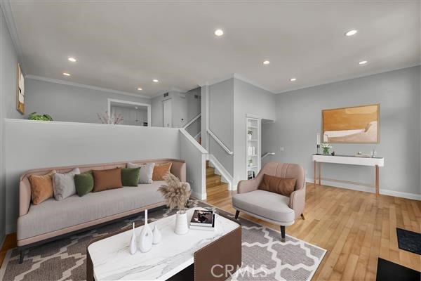 living area featuring wood finished floors, baseboards, stairway, and recessed lighting