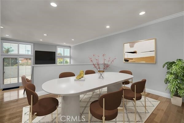 dining area with crown molding and light hardwood / wood-style floors