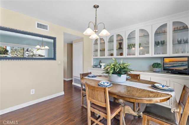 dining area featuring an inviting chandelier and dark hardwood / wood-style floors