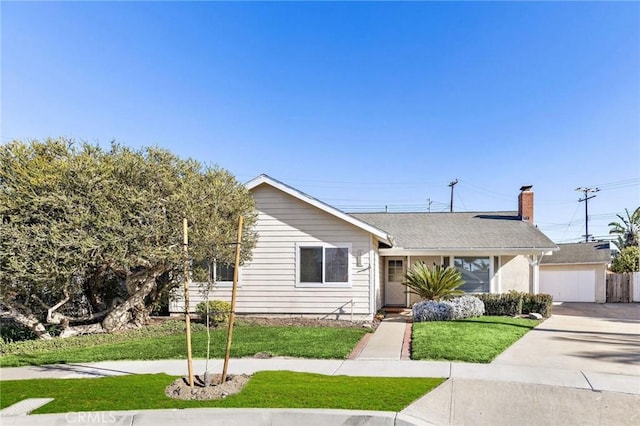 ranch-style house featuring a garage and a front lawn