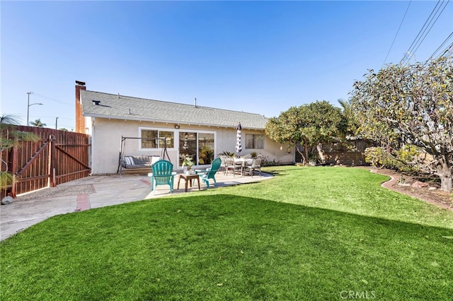 rear view of property featuring a patio and a lawn