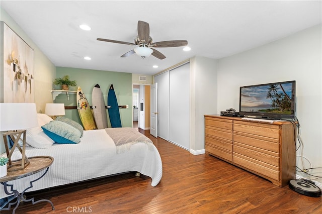 bedroom featuring dark hardwood / wood-style floors, ceiling fan, and a closet