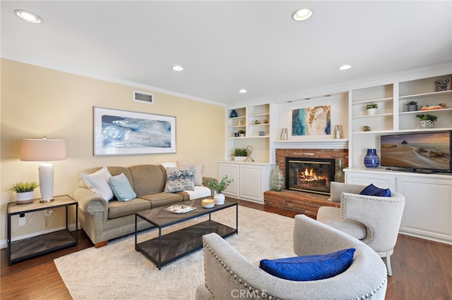 living room with crown molding, a fireplace, and hardwood / wood-style flooring