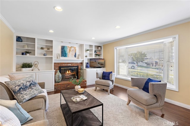 living room featuring wood-type flooring, ornamental molding, a fireplace, and built in shelves