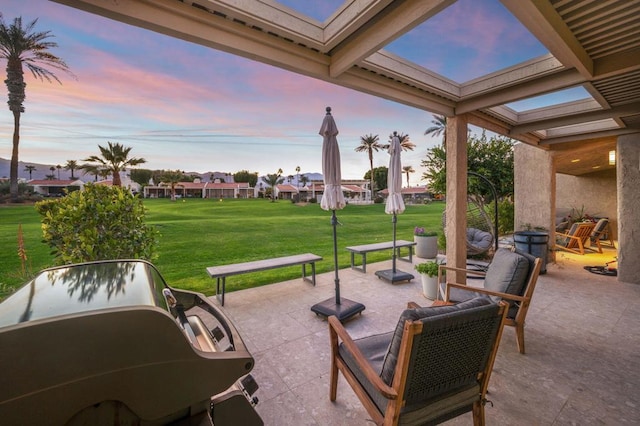 patio terrace at dusk featuring a yard