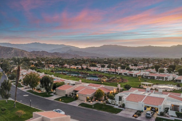 aerial view at dusk featuring a mountain view