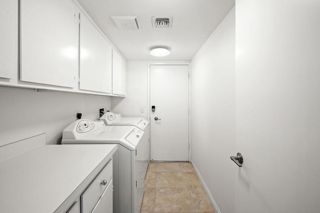 clothes washing area featuring cabinets and washing machine and clothes dryer