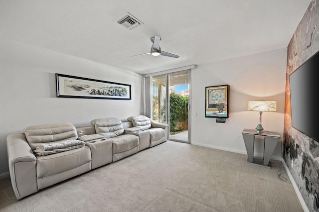 home theater room featuring ceiling fan and light colored carpet