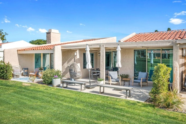 rear view of property featuring a yard and a patio area