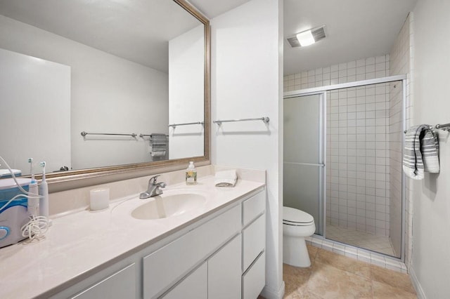 bathroom featuring vanity, toilet, and a shower with shower door