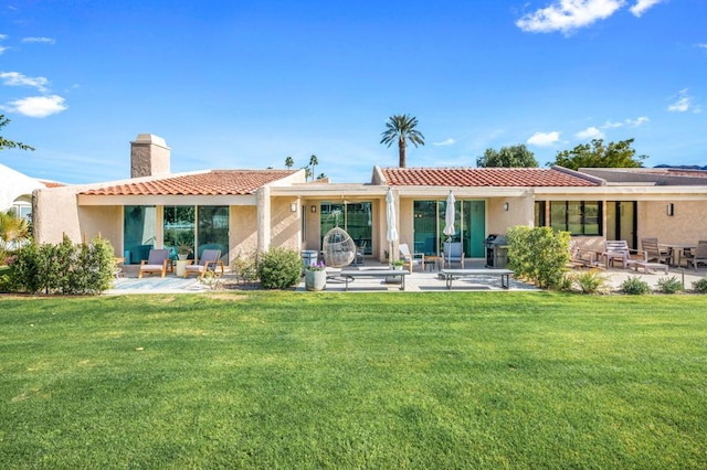 rear view of house featuring a yard and a patio area