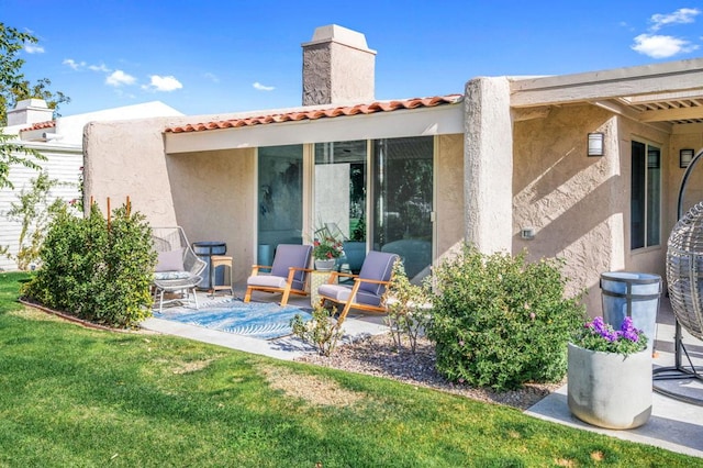 rear view of house featuring a yard and a patio area