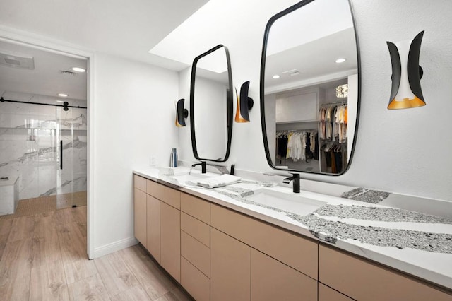 bathroom featuring hardwood / wood-style flooring, vanity, and an enclosed shower