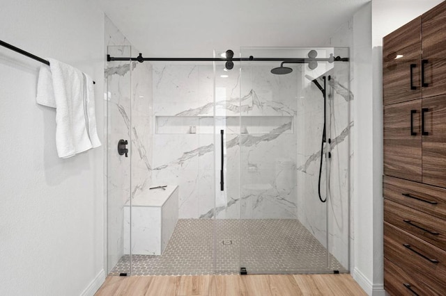 bathroom with wood-type flooring and an enclosed shower