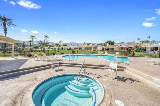 view of swimming pool with a hot tub and a patio