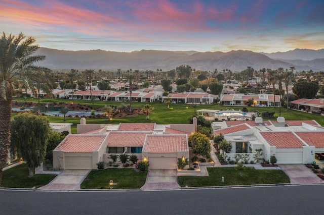 aerial view at dusk featuring a mountain view