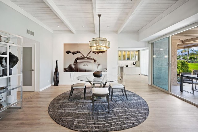 dining space featuring hardwood / wood-style flooring, a chandelier, and beamed ceiling