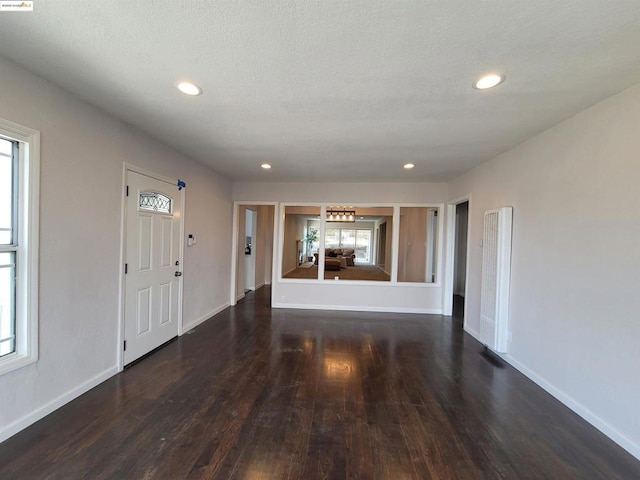 entrance foyer featuring a textured ceiling and dark hardwood / wood-style flooring