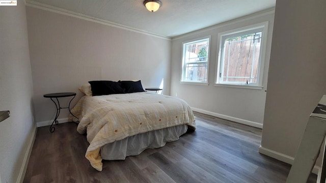 bedroom featuring crown molding and dark hardwood / wood-style floors