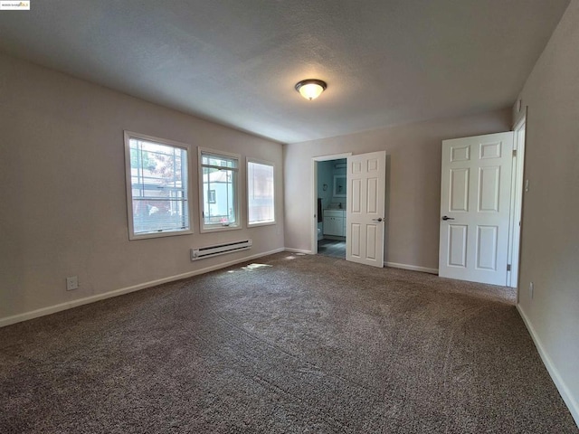 unfurnished bedroom featuring a baseboard heating unit and dark colored carpet