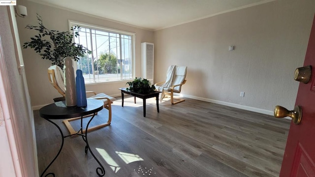 living area with dark hardwood / wood-style flooring, crown molding, and a healthy amount of sunlight