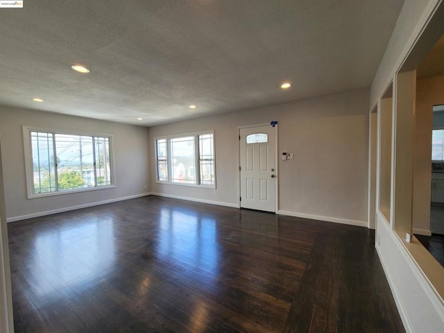 foyer with dark wood-type flooring and a textured ceiling