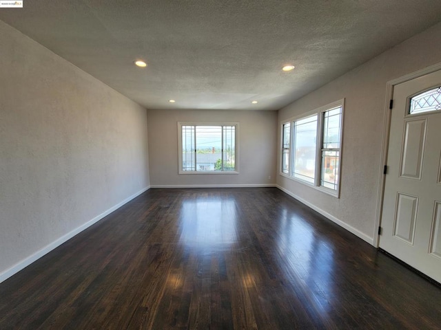 entryway with dark hardwood / wood-style floors and a textured ceiling