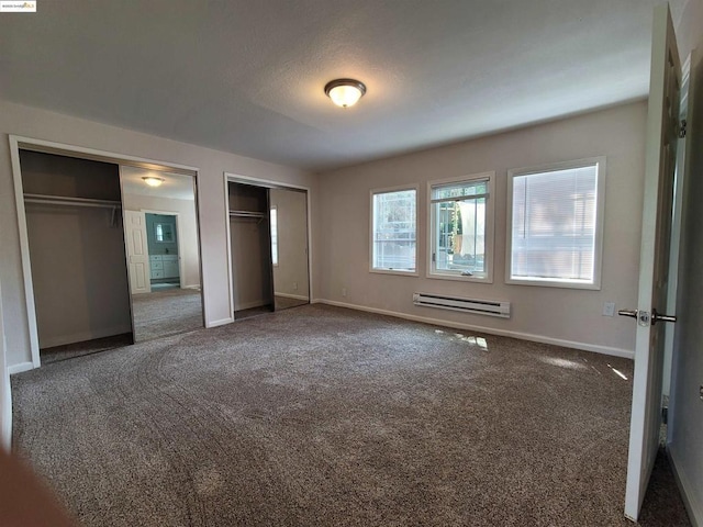 unfurnished bedroom with multiple closets, a baseboard radiator, and dark carpet