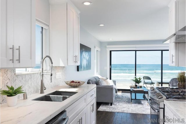 kitchen with white cabinetry, sink, stainless steel appliances, and a water view