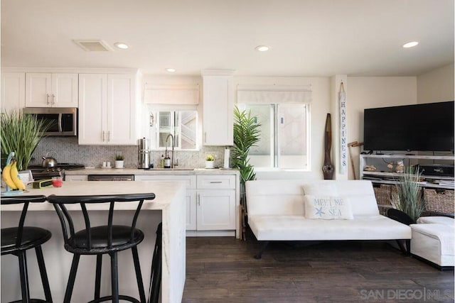 kitchen with stainless steel appliances, sink, a wealth of natural light, and white cabinets