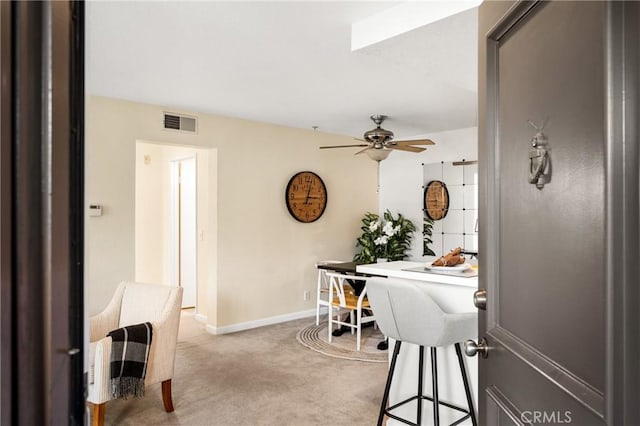 dining area featuring light carpet and ceiling fan