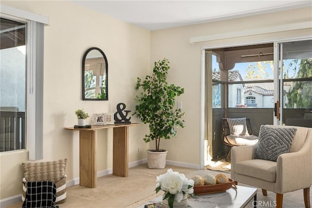 living area featuring plenty of natural light and light colored carpet