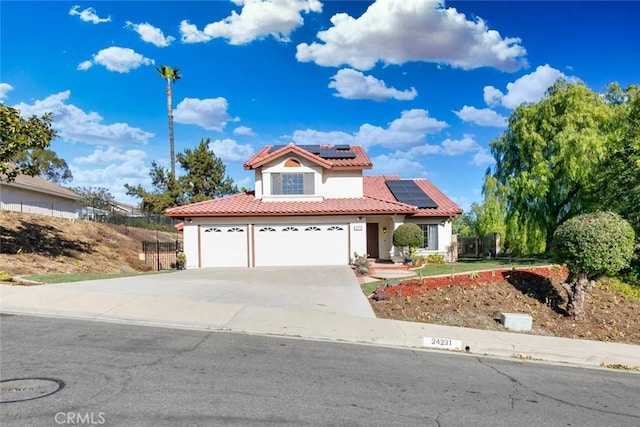 mediterranean / spanish-style house with a garage and solar panels