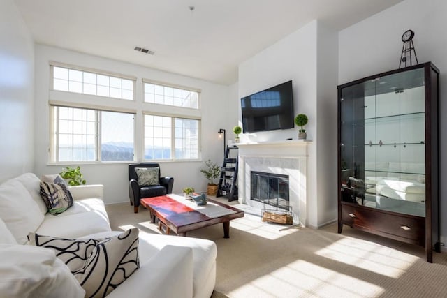 carpeted living room featuring a premium fireplace