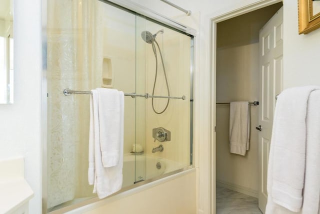 bathroom featuring bath / shower combo with glass door and vanity