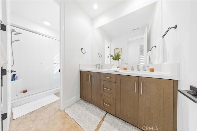 bathroom featuring tile patterned flooring, vanity, and a shower with shower door