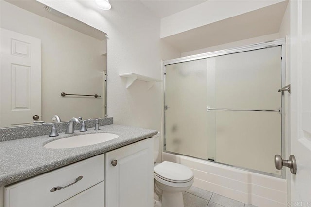 full bathroom with vanity, tile patterned floors, shower / bath combination with glass door, and toilet