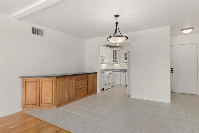 kitchen featuring white appliances, decorative light fixtures, and white cabinets