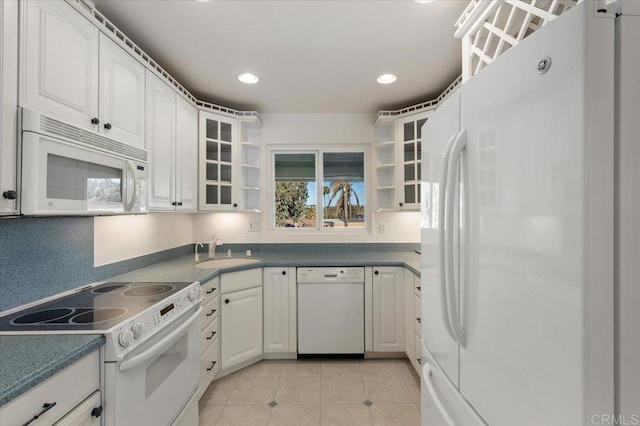 kitchen featuring white cabinetry, sink, light tile patterned flooring, and white appliances