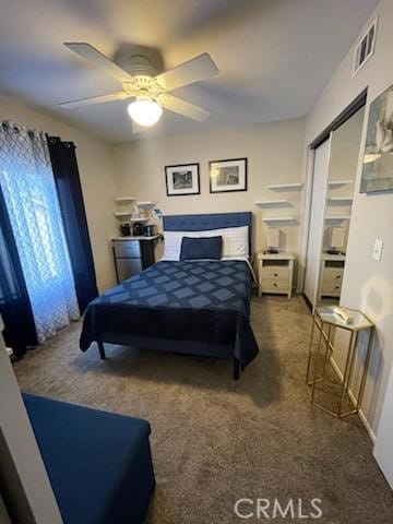 carpeted bedroom featuring ceiling fan and a closet