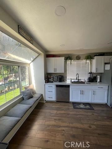 kitchen featuring dark hardwood / wood-style floors, refrigerator, sink, white cabinets, and stainless steel dishwasher